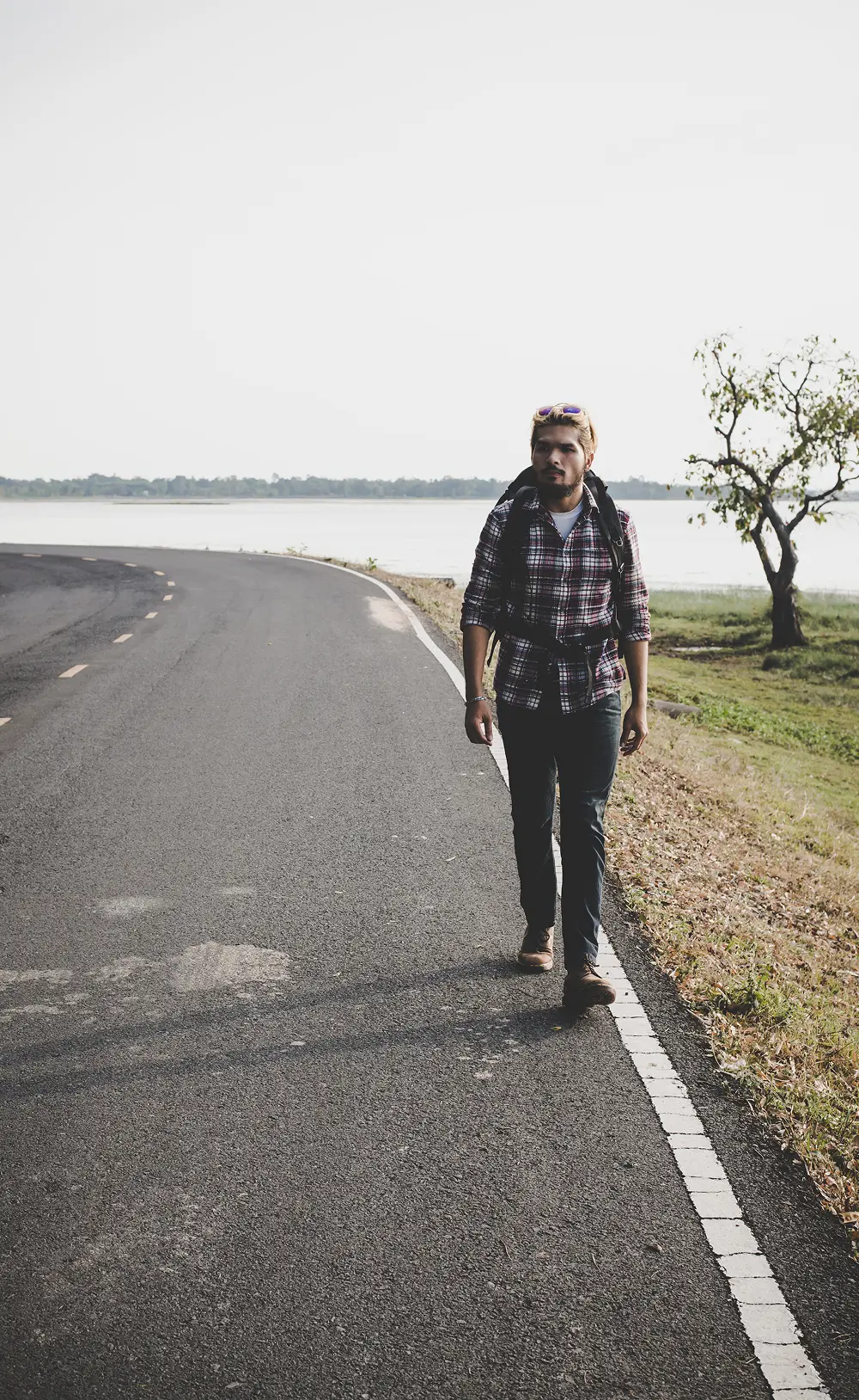 Man walking along a quiet lakeside road to cope with anxiety and clear his mind