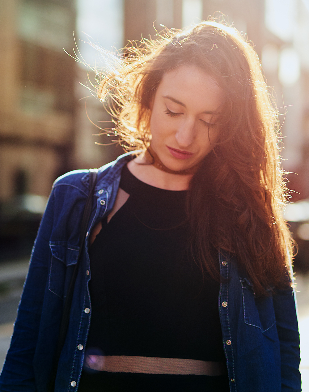 An introspective woman looking down thoughtfully, reflecting on personal growth and wellness counseling options.
