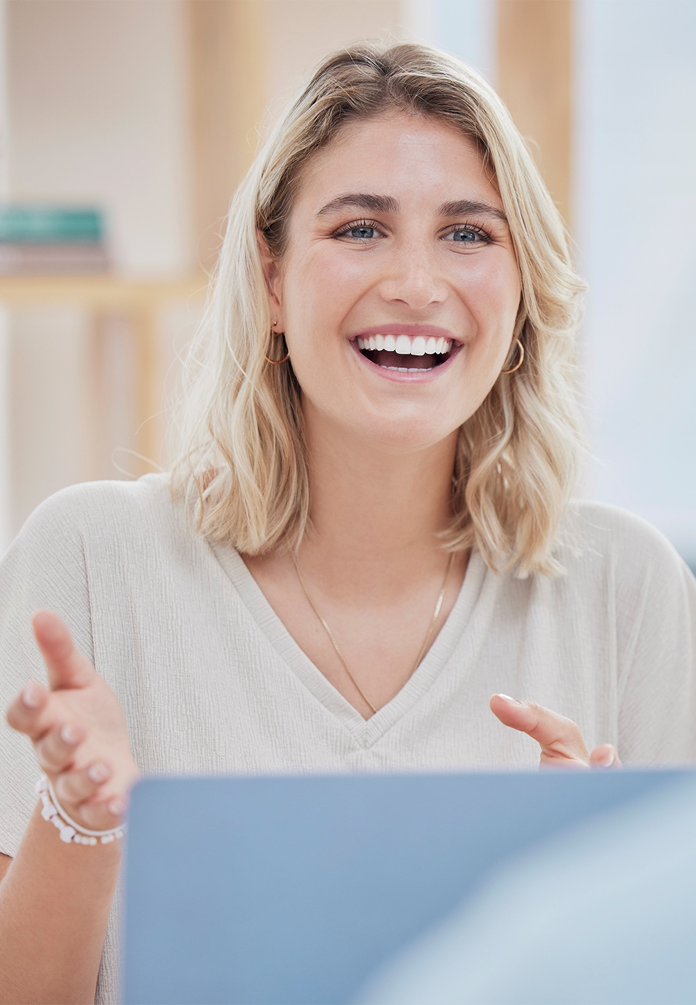 A smiling female therapist gesturing during an online counseling session at Great Lakes Wellness Counseling.